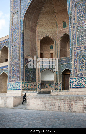 Uzbekistan, Bukhara, Mir-i Arab Madrasah, person hurring up the steps Stock Photo