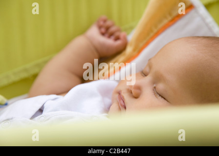 Baby sleeping in crib, side view Stock Photo