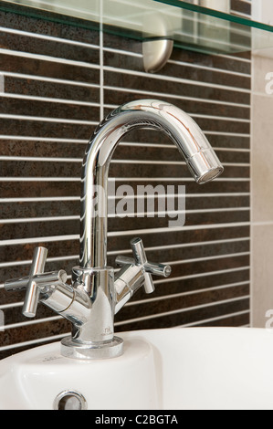Close up of a mixer tap on a sink in a modern bathroom. Stock Photo