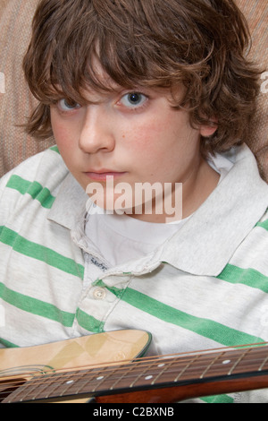 Boy age 12 practicing his guitar. St Paul Minnesota MN USA Stock Photo