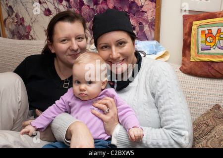 Two loving sisters holding baby ages 29 and 39. St Paul Minnesota MN USA Stock Photo