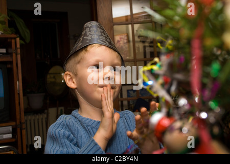 Boy age 4 enjoying Christmas tree at New Year's Eve Party. St Paul Minnesota MN USA Stock Photo