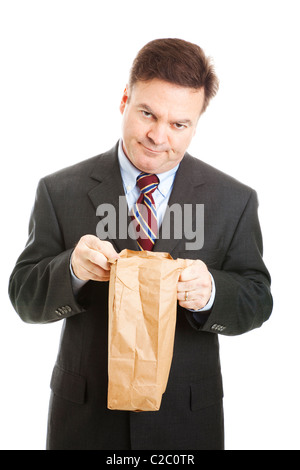 Disappointed businessman having to bring his lunch in a bag to save money. Isolated. Stock Photo