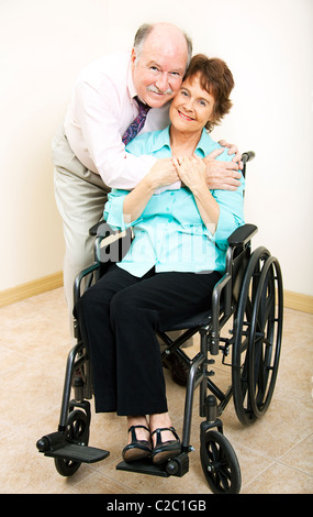 Loving middle-aged husband and wife. She is in a wheelchair.  Stock Photo