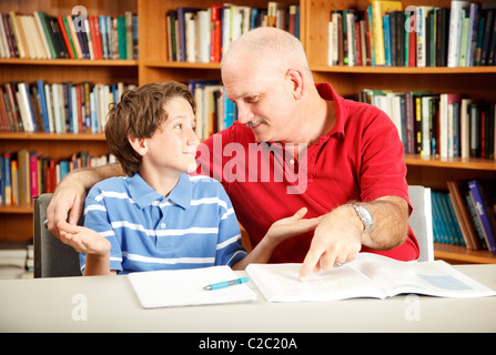 Teacher or parent working with a young boy who has learning disabilities.  Stock Photo