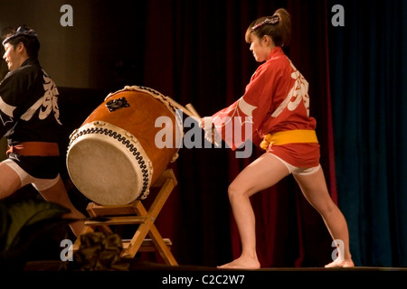 A disabled Japanese women and man with impaired hearing (deaf) are playing taiko drums In communist Laos. Stock Photo