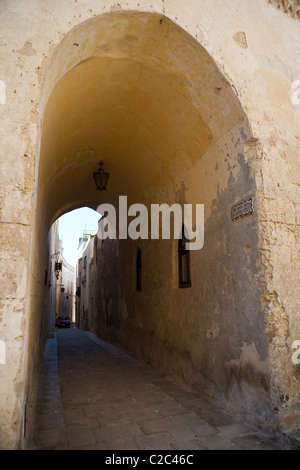 An Arched entrance to a narrow walk way in the historic town of Mdina in Malta Stock Photo