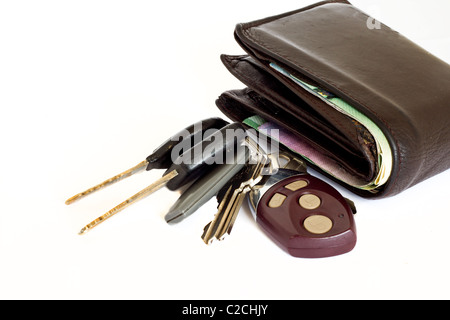 Car keys with an alarm along side a thick brown leather wallet on a white background Stock Photo