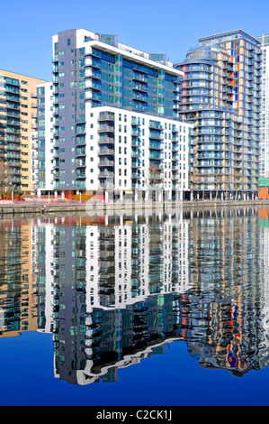 Reflection on water of urban flat apartment housing in real estate development in regeneration of Inner Millwall Dock Isle of Dogs East London UK Stock Photo