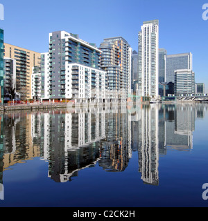 Reflection on water of urban flat apartment housing in real estate development in regeneration of Inner Millwall Dock Isle of Dogs East London UK Stock Photo