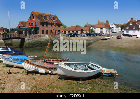 Colorful boats lay on the mud as the tide recedes. Stock Photo