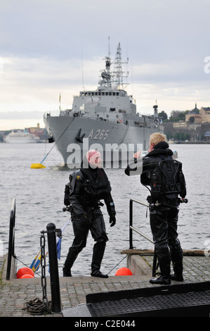 Scuba divers and battleship of the Swedish Navy at the harbor of Stockholm, Stockholms Lan, Sweden Stock Photo