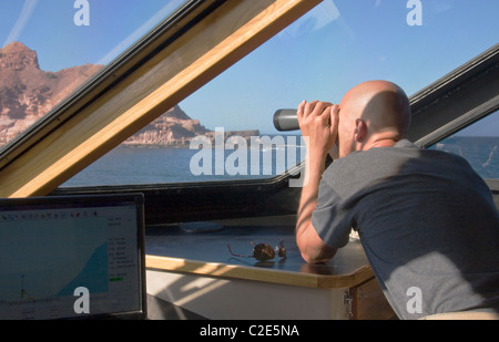 Safari Quest engineer, Dirk Boschek, searches for whales from the wheelhouse, Sea of Cortez, Baja California, Mexico. Stock Photo