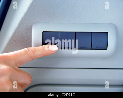finger on buttons of device in a car Stock Photo