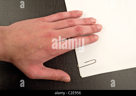 Hand on document with paperclip Stock Photo