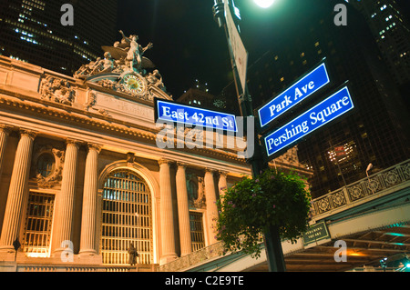 Illuminated Grand Central Terminal building at night on East 42nd Street, Manhattan, New York City, USA. Iconic landmark with street signs. Stock Photo