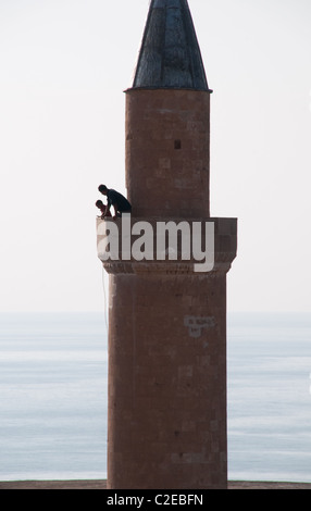A man and his son atop a mosque minaret overlooking the waters of Lake Van, at the Van citadel in the city of Van, Turkey. Stock Photo