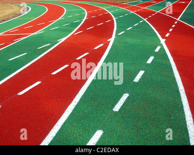 A running track in a stadium with markings in white, red and green and solid and broken lines Stock Photo