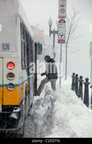 A man boards a bus during a winter snow storm in Boston Massachusetts Stock Photo