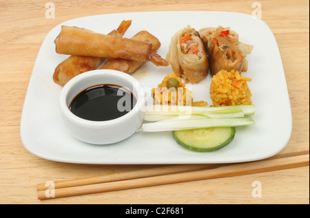 Selection of Chinese snacks on a plate on a wooden table Stock Photo