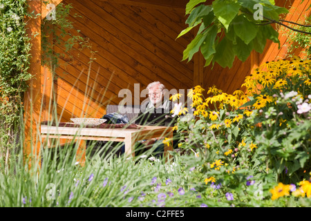 Senior resting on a chair in summer garden Stock Photo