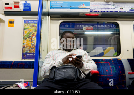 Black man uses his smartphone on the London Underground Stock Photo