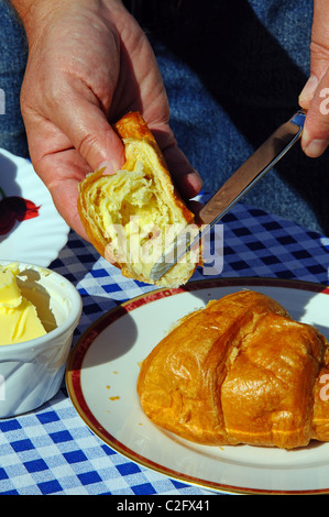 Buttering a croissant, Andalucia, Spain, Western Europe. Stock Photo