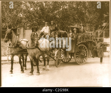 Horse Drawn Fire engine pumper with department poses for the camera in uniform Stock Photo