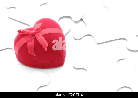 red gift box in heart shape on puzzles Stock Photo