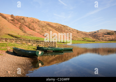Two boats and reflections of fells in Watendlath Tarn in the Lake District National Park in early summertime. Watendlath, Cumbria, England, UK Stock Photo