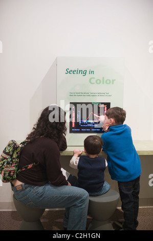 Hispanic Mother  with 5 year old and two year old view  'Seeing in Color' exhibit at the Harvard Museum of Natural History Stock Photo