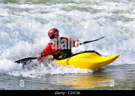 Playboating whitewater kayaker surfing on wave, Rhone River in near Lyon, Sault Brenaz, France Stock Photo