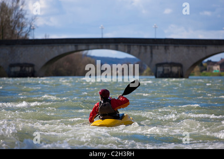Whitewater kayaker in front of a bridge on River Rhone near Lyon, Sault Brenaz, France Stock Photo