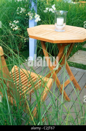 Wooden table and chair on under a blue painted pergola Stock Photo