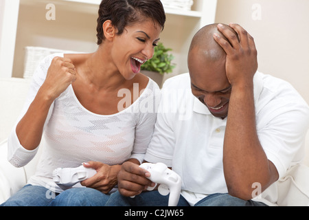 African American couple, man and woman, having fun playing video console games together. Stock Photo