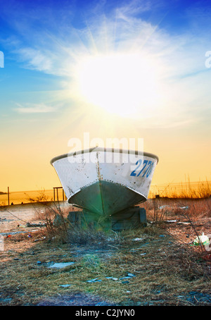 Old fisherman boat at sunrise time on the beach Stock Photo