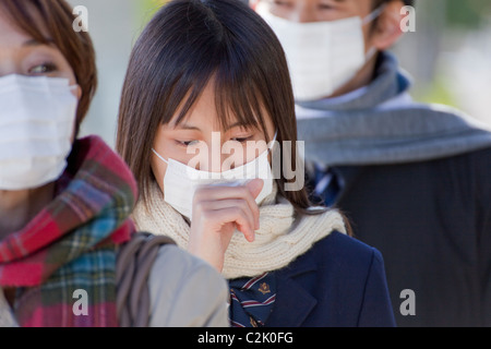 High School Girl with Mask Standing and Coughing Stock Photo