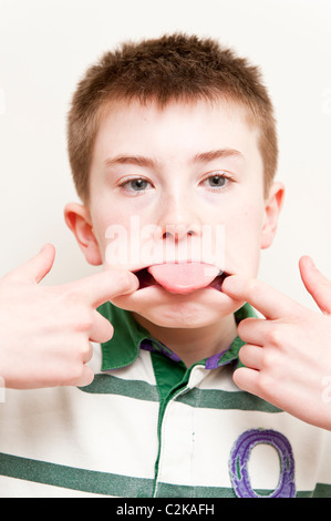A MODEL RELEASED picture of an eleven year old boy pulling a funny face indoors Stock Photo