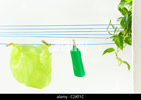 Green plastic objects hanging on a washing line. Stock Photo