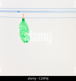 Green plastic objects hanging on a washing line. Stock Photo