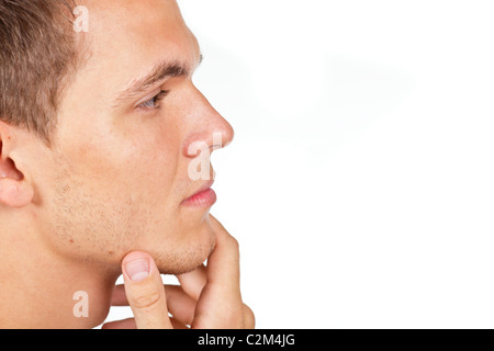 Closeup portrait of a thoughtful young man with hand on his chin Stock Photo