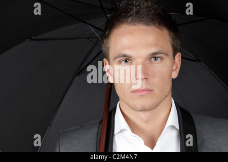 Businessman with white umbrella protecting himself from the storm ...