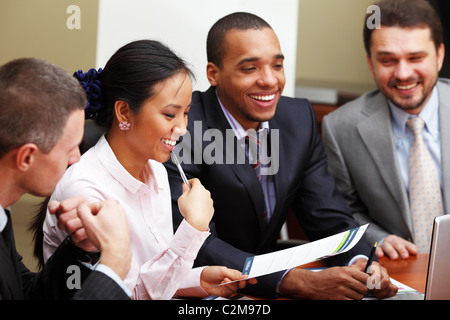 Multi ethnic business team at a meeting. Interacting. Focus on woman Stock Photo