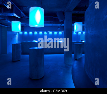 Matter, The O2 Arena, Peninsula Square, London. drum tables of concrete and bar with blue lights Stock Photo