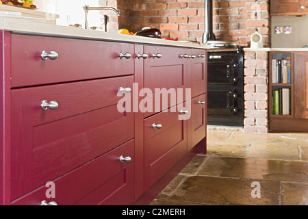 Traditional frmhouse kitchen with flagstone floor and Shaker-style cupboards and drawers Stock Photo