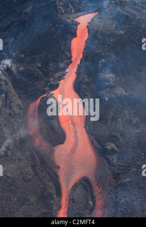 Lava from Eyjafjallajokull volcano flowing down mountain, silhouetted against sunset, Southern Iceland Stock Photo