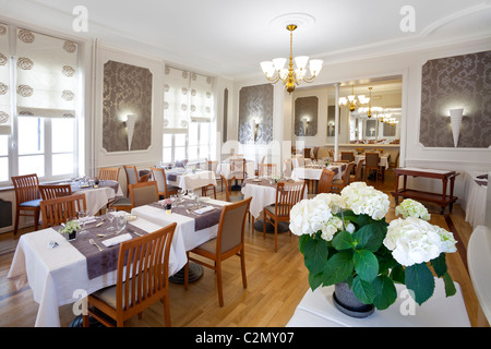 A pot of white hydrangeas in a restaurant dining room (France). Potée d'hortensias blancs dans une salle de restaurant (France). Stock Photo
