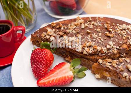 Walnut Cake With Strawberries and Cup of Coffee on Table Stock Photo