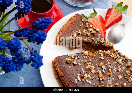 Walnut Cake With Strawberries and Cup of Coffee on Table Stock Photo