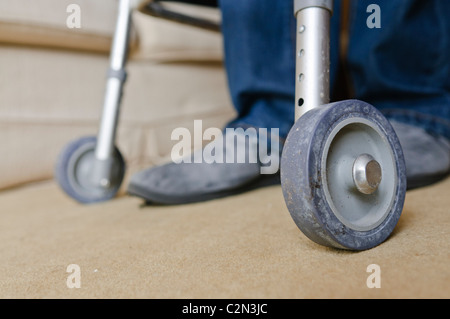 Man in his 40's using a walking assistance frame due to inability to walk due to rheumatoid arthritis and painful joints. Stock Photo